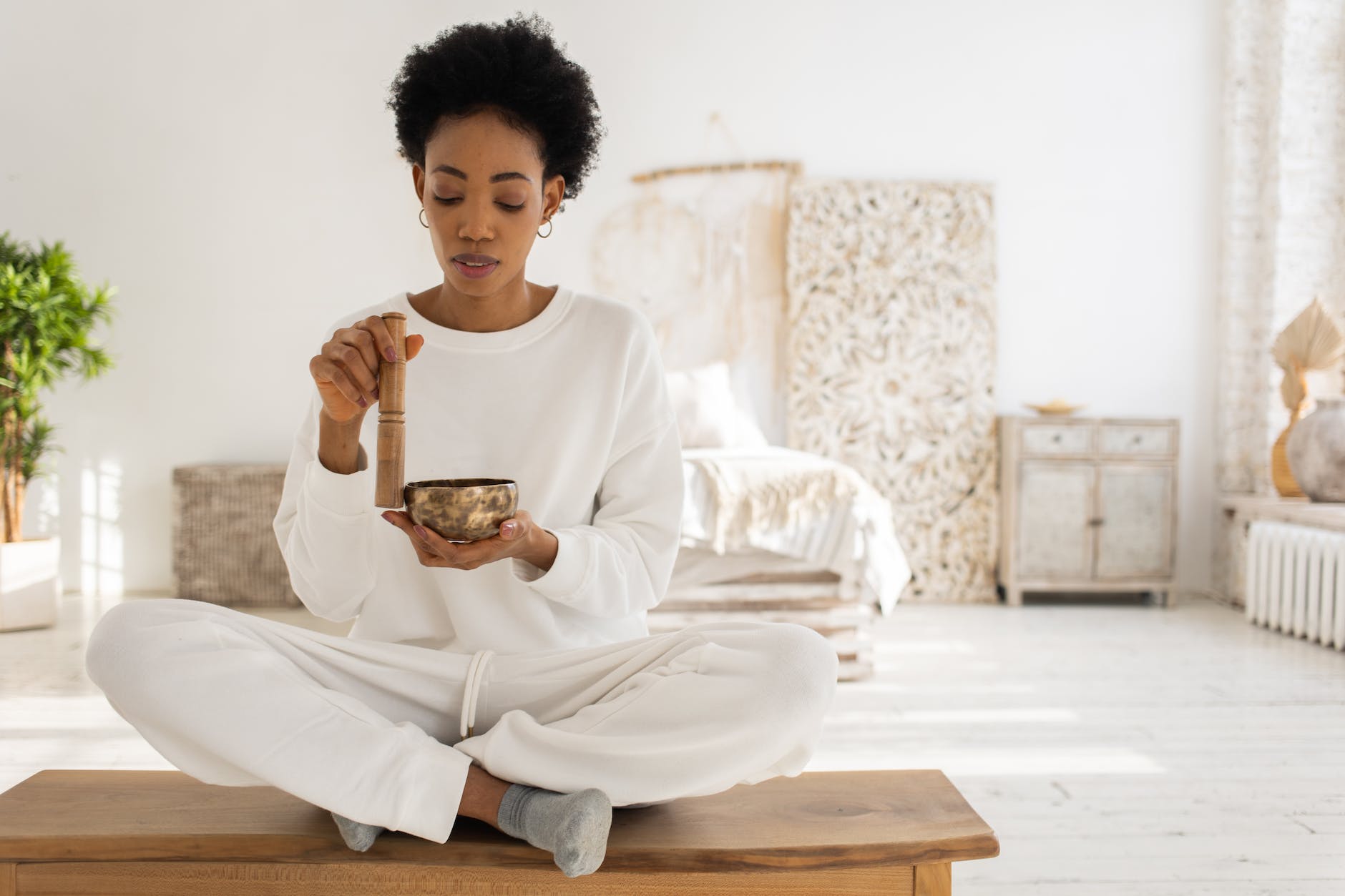 a woman using a singing bowl while sitting